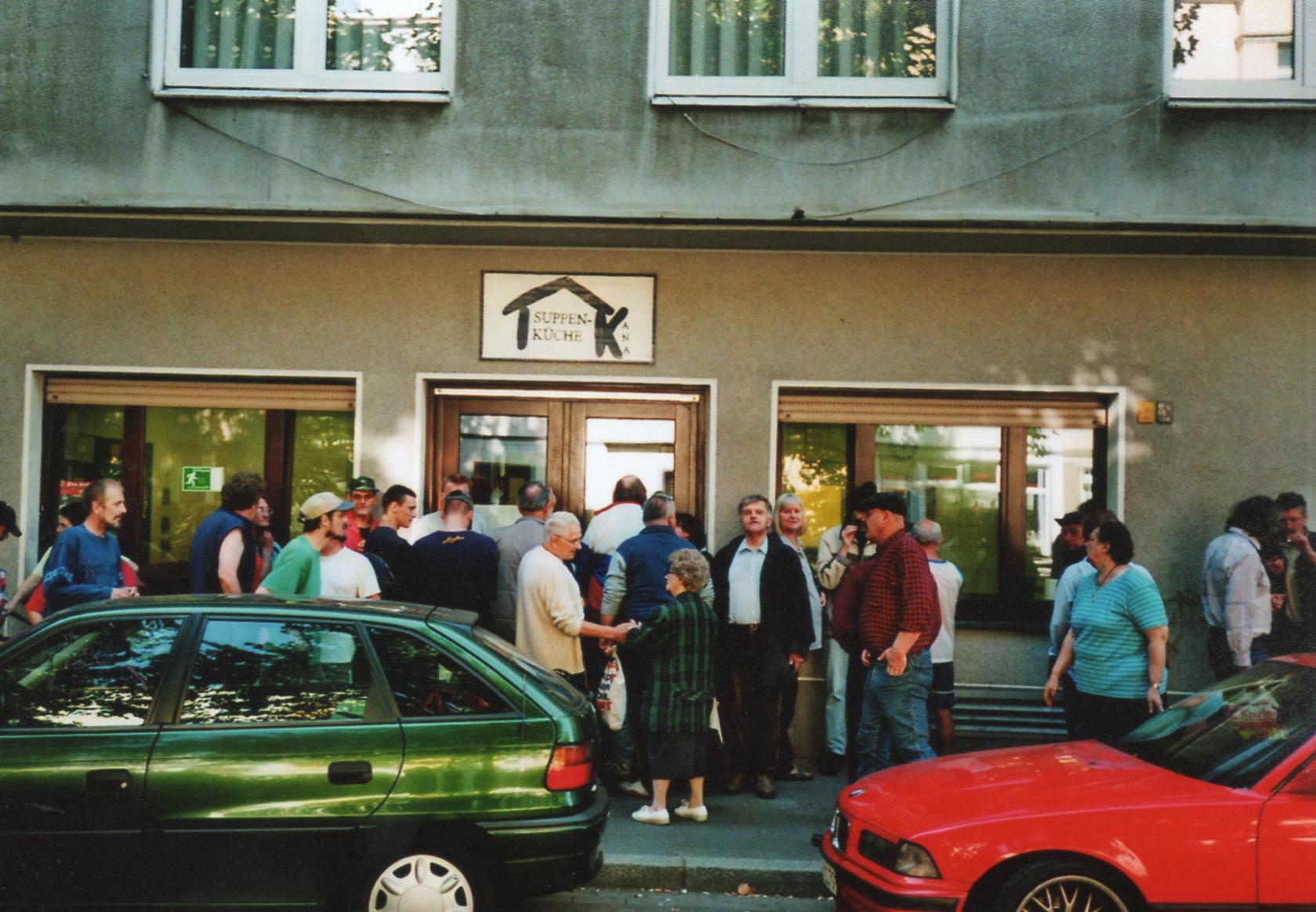 Ansicht Ladenzeile mit wartenden Menschen